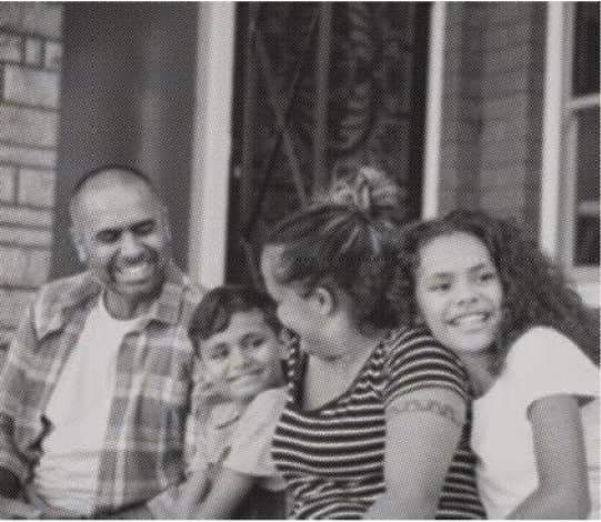 A young family of four share a laugh
