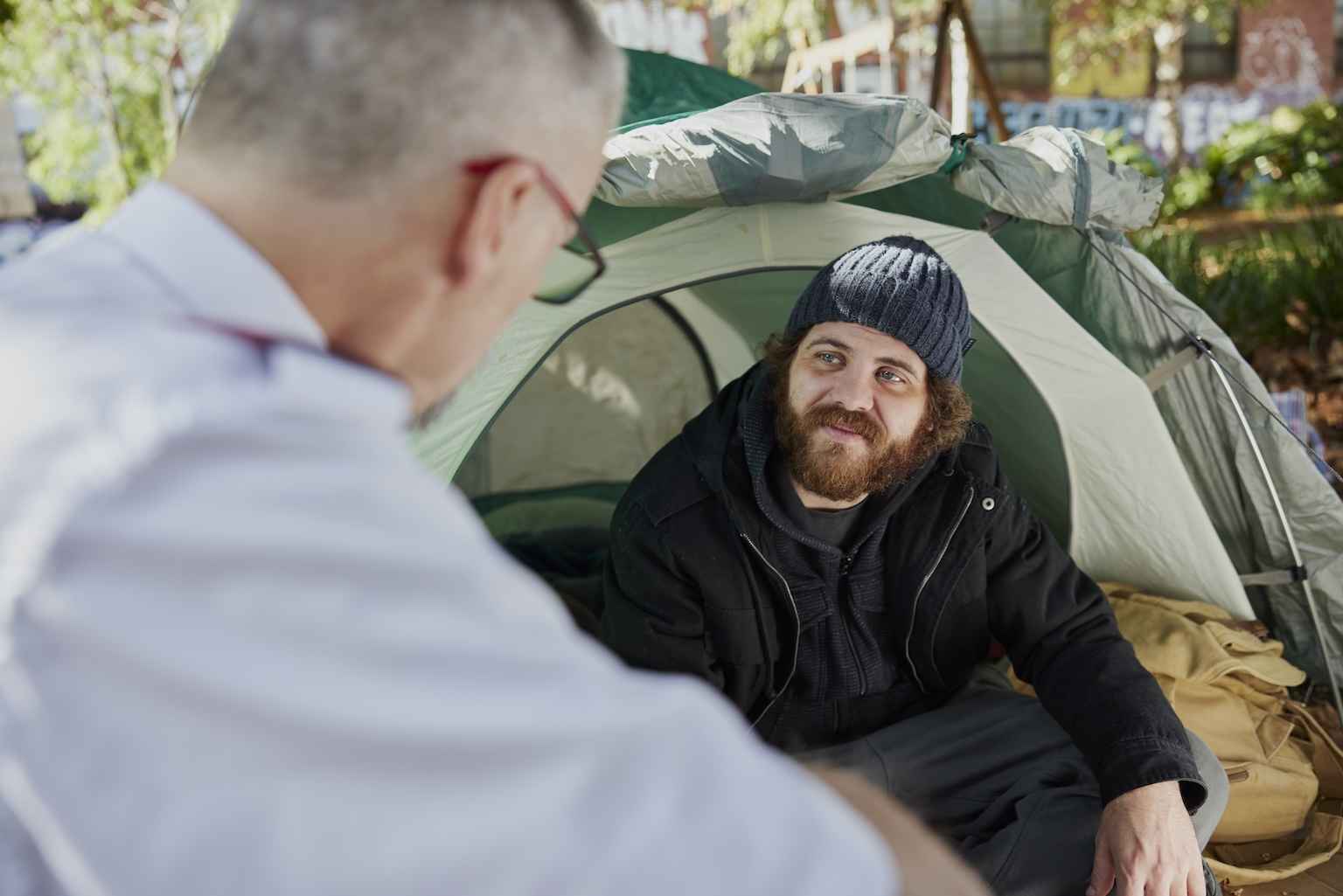 A Salvos officer talks with a young man forced to live in a tent
